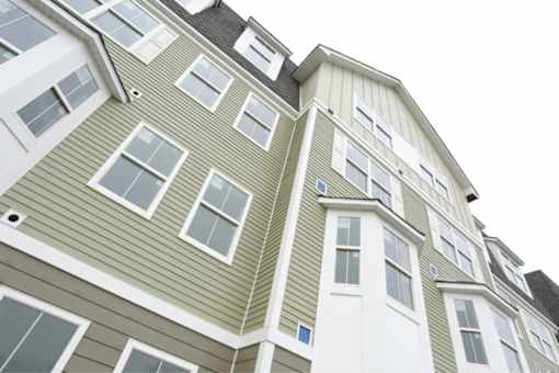 a green and white apartment building with windows