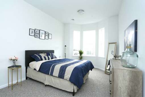 a bedroom with a bed and a large window