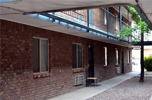 a brick building with a balcony and a chair
