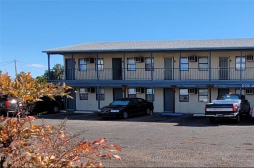 a motel with cars parked in front of it
