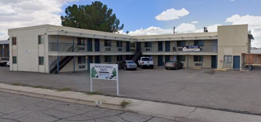 a motel with a sign in front of a parking lot