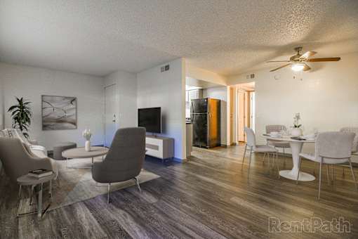 A living room with a grey sofa and a wooden floor.