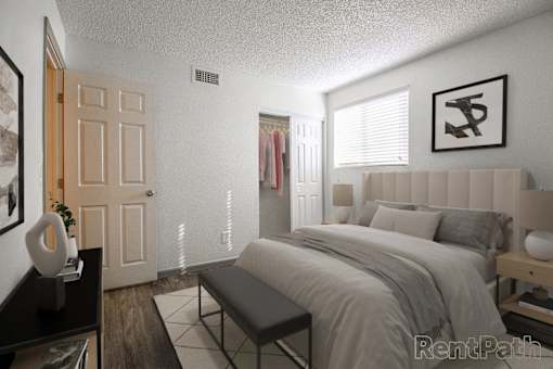 A bedroom with a large bed and a bench in front of it.