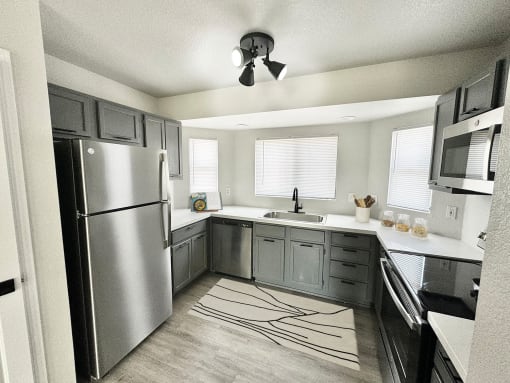 a kitchen with stainless steel appliances and gray cabinets