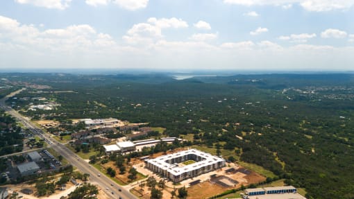 an aerial view of a campus with a large building and a highway at Birdie on Woodland Greens, Austin, 78726