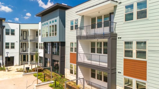 a row of new apartment buildings with stairs and balconies at Birdie on Woodland Greens, Austin, Texas