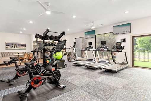 a gym with exercise bikes and a wall with graffiti at Radius on Grove, Austin, TX