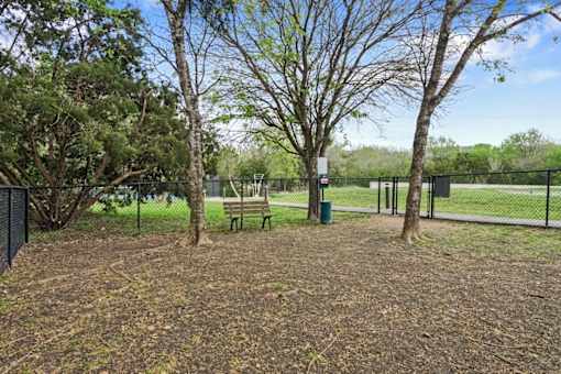 a park with a bench and trees and a fence at Radius on Grove, Austin, Texas