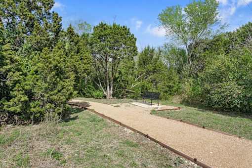 a park with a bench and a dirt path at Radius on Grove, Texas