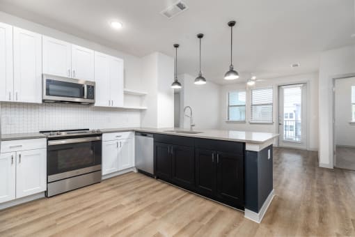 a white and black kitchen with white cabinets and a wood floor at Birdie on Woodland Greens, Austin, Texas