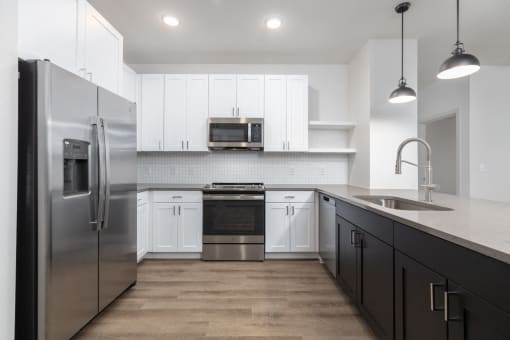 a kitchen with white cabinets and stainless steel appliances at Birdie on Woodland Greens, Austin, Texas