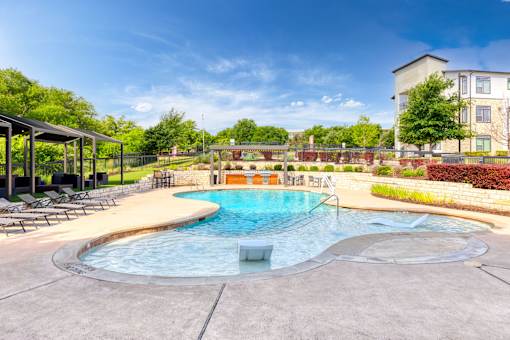 our apartments have a resort style pool with lounge chairs at Radius on Grove, Texas, 78741