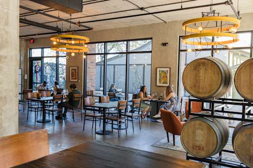 Tasting room with wine barrels and seating at THE'68 Apartments, San Antonio, Texas