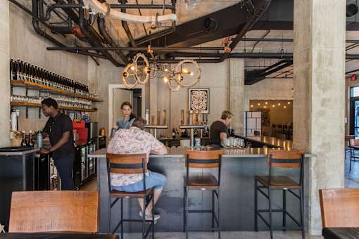 Industrial style bar with exposed ceiling beams at THE'68 Apartments, San Antonio, 78205