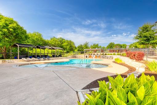 a swimming pool with trees in the background and a blue sky at Radius on Grove, Austin