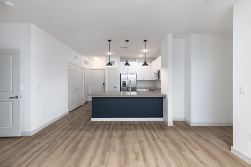 a kitchen and living room with white walls and wood floors at Birdie on Woodland Greens, Texas