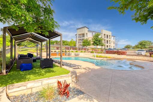 a swimming pool with a pavilion and a building in the background at Radius on Grove, Austin, TX