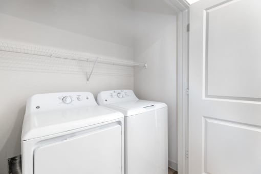 a white laundry room with two washes and a dryer at Birdie on Woodland Greens, Austin, TX