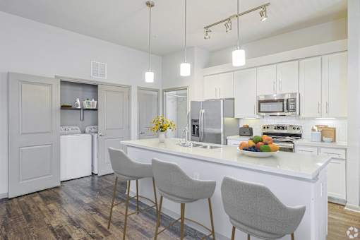 A kitchen with a white countertop and grey chairsat Radius on Grove, Austin