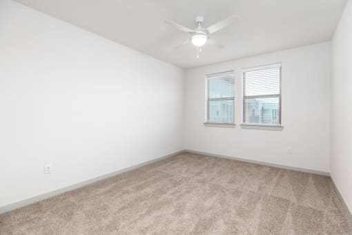 an empty room with a window and a ceiling fan at Birdie on Woodland Greens, Texas