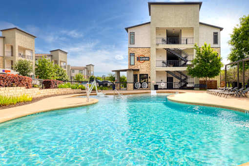 a swimming pool with a building in the background at Radius on Grove, Texas, 78741