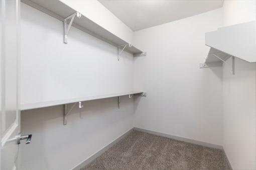 an empty room with white walls and shelves and a closet at Birdie on Woodland Greens, Texas