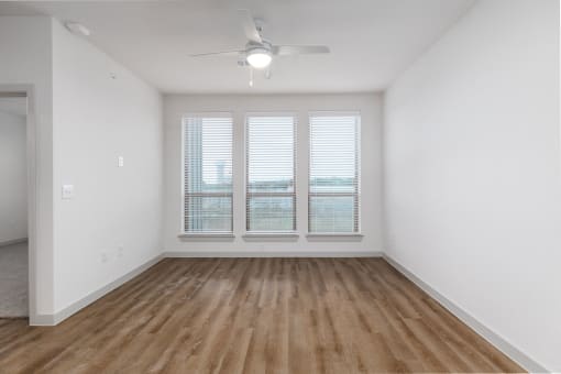 an empty living room with white walls and a ceiling fan at Birdie on Woodland Greens, Austin, Texas