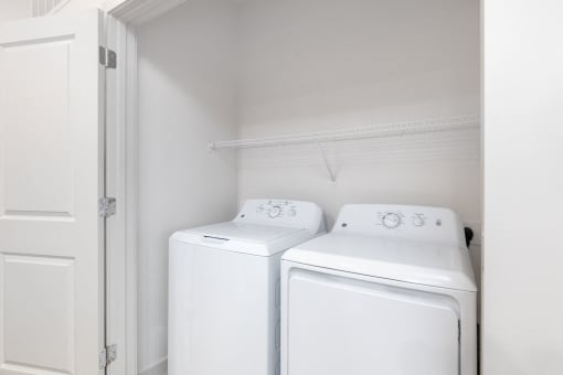 a white laundry room with two washes and a dryer at Birdie on Woodland Greens, Austin, 78726