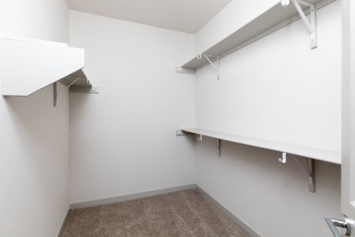 an empty room with white walls and white shelves and hooks on the wall at Birdie on Woodland Greens, Austin, 78726