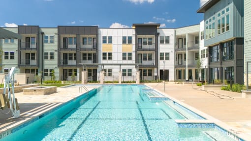 a swimming pool in front of a building at Birdie on Woodland Greens, Austin