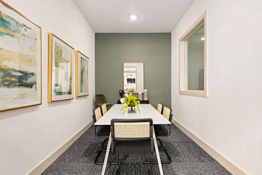 a dining room with a table and chairs and paintings on the wall at Radius on Grove, Austin, TX