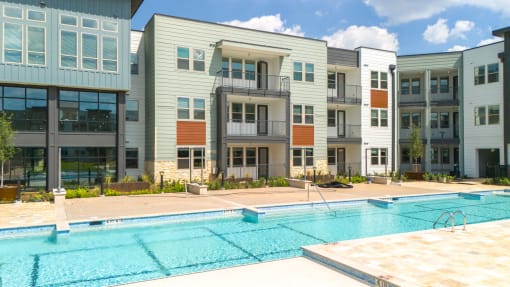 an image of a swimming pool in front of an apartment building at Birdie on Woodland Greens, Austin, 78726