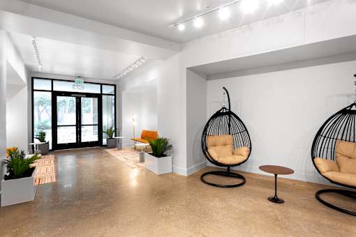 Modern lobby entrance with hanging egg chairs at THE'68 Apartments, San Antonio, TX