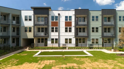 an exterior view of an apartment building with green grass at Birdie on Woodland Greens, Austin, TX