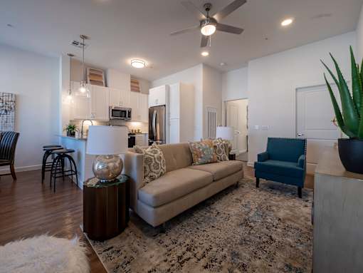 A living room with a couch, a chair, a table, and a rug.
