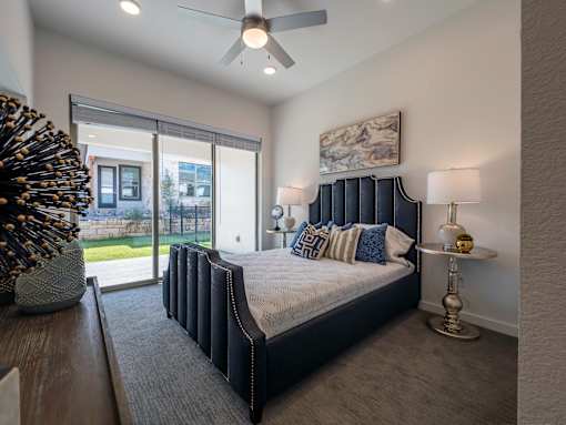 A bedroom with a large bed and a ceiling fan.