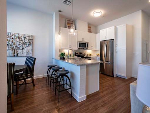 A kitchen with a bar area and a refrigerator.