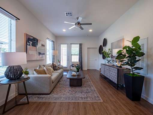 A living room with a couch, a coffee table, and a ceiling fan.