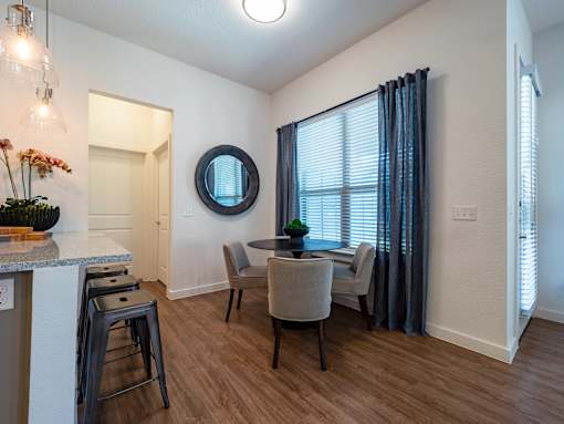 A dining room with a table and chairs.