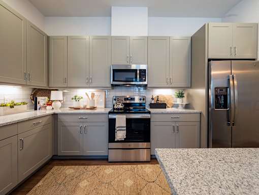 A kitchen with a refrigerator, oven, and microwave.