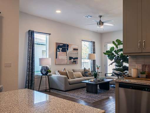 A living room with a couch, a table, and a painting on the wall.