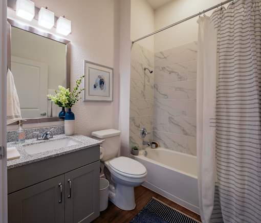 A bathroom with a toilet, sink, and bathtub.