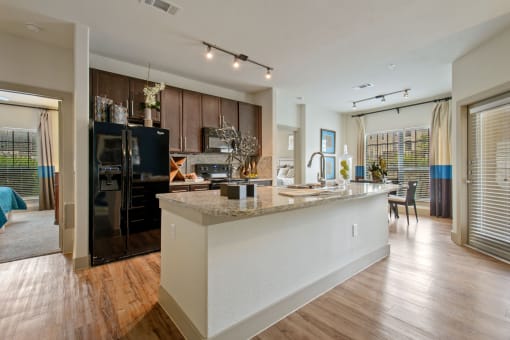 a kitchen and living room with a large island with granite countertops at Alvista Round Rock, Round Rock, 78664