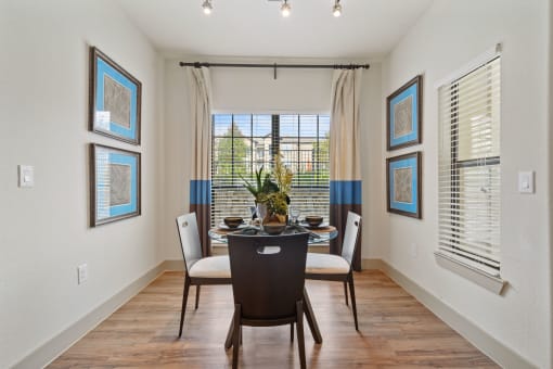 a dining room with a table and chairs in front of a window with blinds at Alvista Round Rock, Round Rock, TX, 78664