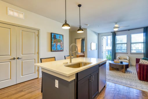 a kitchen with an island and a living room with a couch at Birdie on Woodland Greens, Texas 78726
