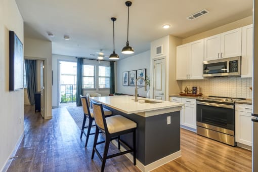 an open kitchen with a large island with chairs and a counter at Birdie on Woodland Greens, Austin