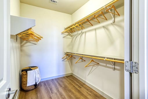 a walk in closet with hanging racks and a basket on the floor at Birdie on Woodland Greens, Texas