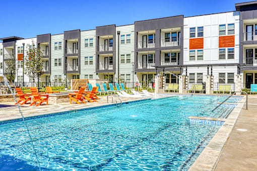 A swimming pool in front of apartment buildings.