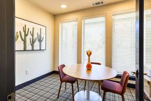 a dining room with a table and chairs and windows at Birdie on Woodland Greens, Austin, TX
