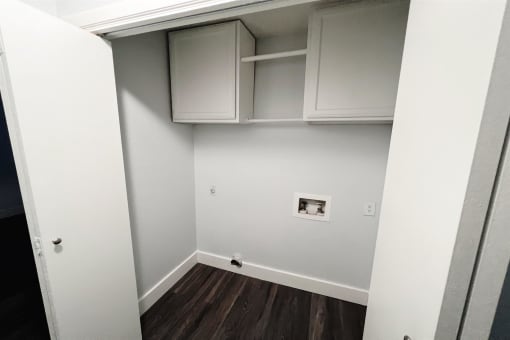 a room with white cabinets and a white wall and wood floors at Northchase, Austin